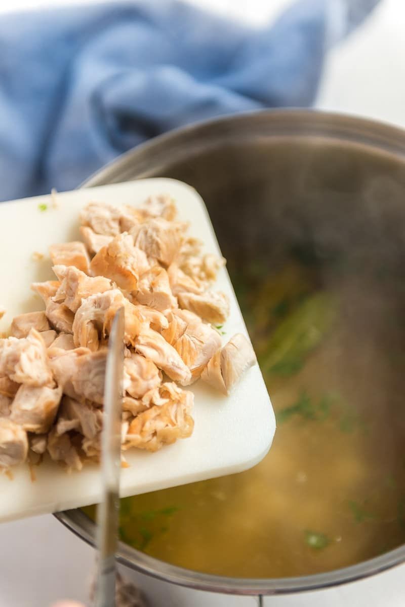 Agregar pollo a la sopa de pollo con fideos con fideos de huevo