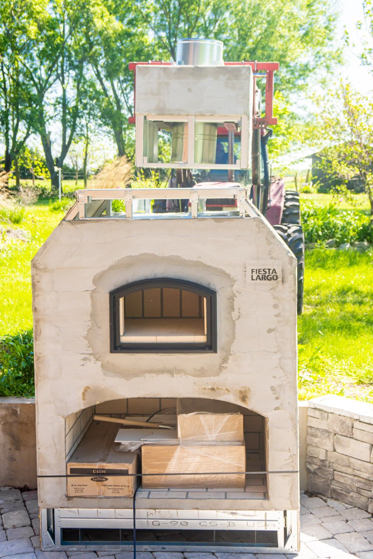 Vorkheftruck plaatsen schoorsteen bovenop bakstenen oven in de achtertuin