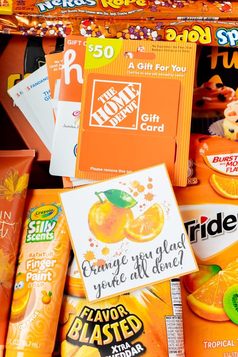 Etiquetas laranja para presente com uma cesta cheia de itens