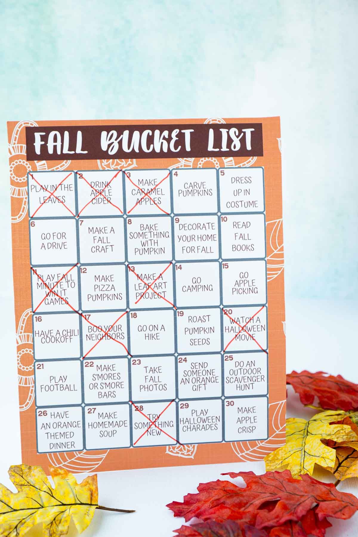 Een herfst-bucketlist met doorgestreepte items omringd door nepblaadjes