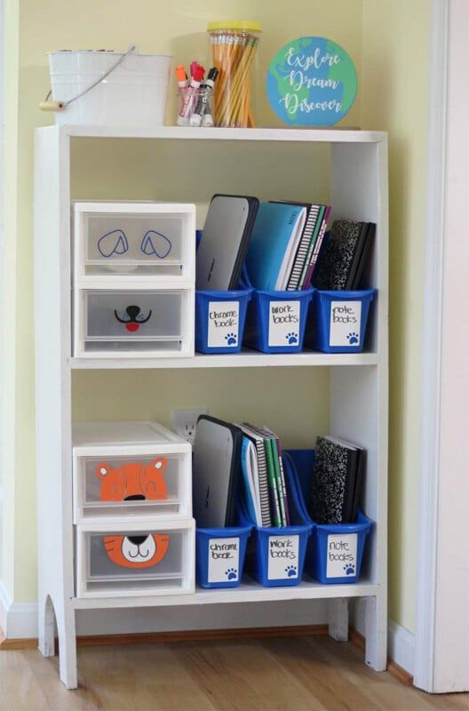 Contenedores de almacenamiento en un estante blanco con útiles escolares dentro