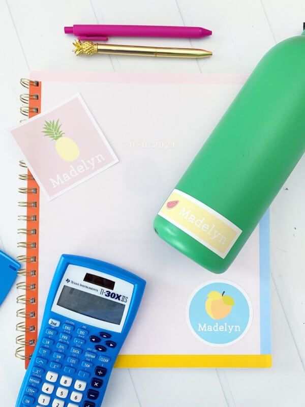 Een notitieboekje met schoolspullen eromheen en gepersonaliseerde stickers om te labelen