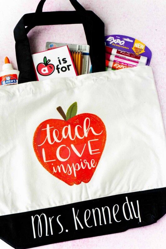Nákupní taška s trčícím jablkem a školními potřebami