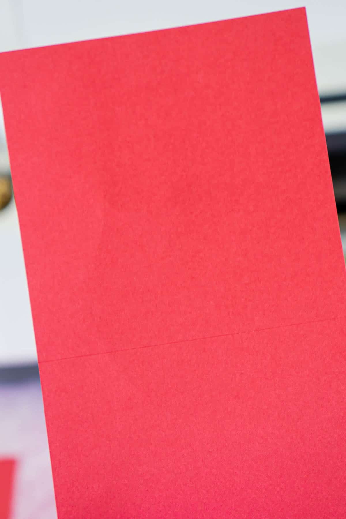 Pedazo de cartulina roja con líneas de puntuación
