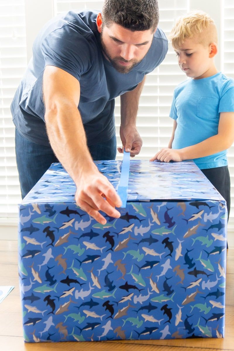 Cerrar la caja de regalo azul con cinta adhesiva