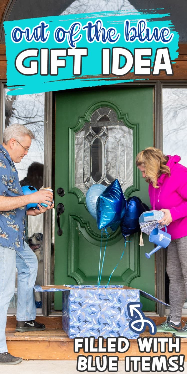 Dve odrasli osebi odpirata zavito darilno škatlo z modrimi baloni