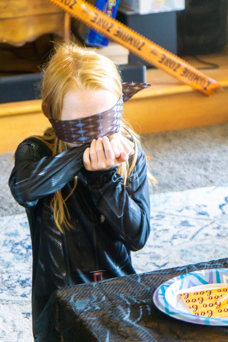 Dívka si utírá ústa během hádání hry Halloween