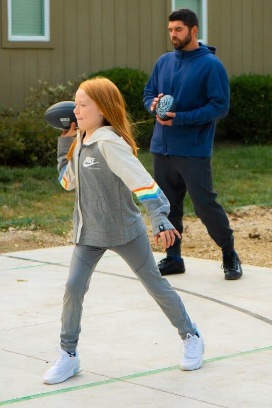 Meitene iemet Nike futbolu pelēkās drēbēs