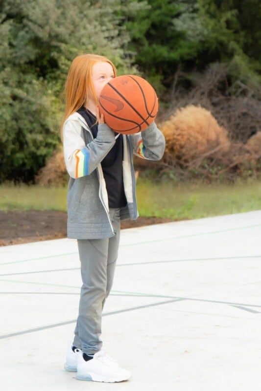 Chica sosteniendo una pelota de baloncesto Nike