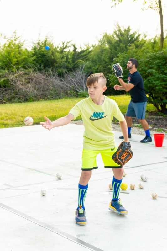 Niño con ropa amarilla filmando una pelota de béisbol