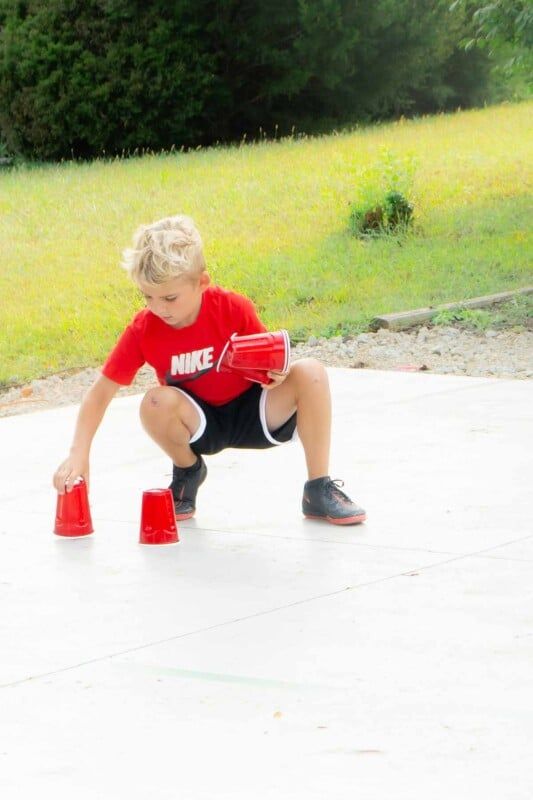 Dítě umisťuje plastové kelímky na basketbalové hřiště