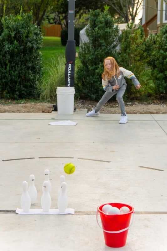 Gadis bermain bola bisbol di pin bowling