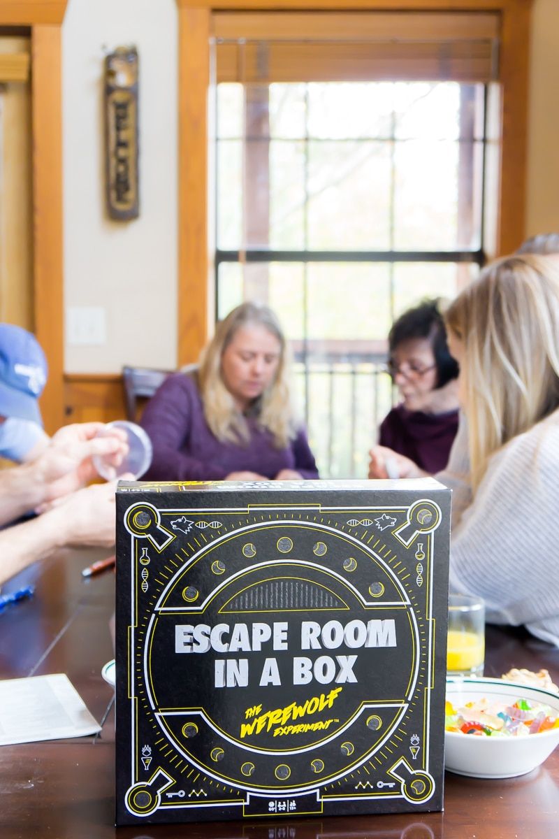 Adultos jugando al mejor juego de mesa de escape room: Escape Room in a Box
