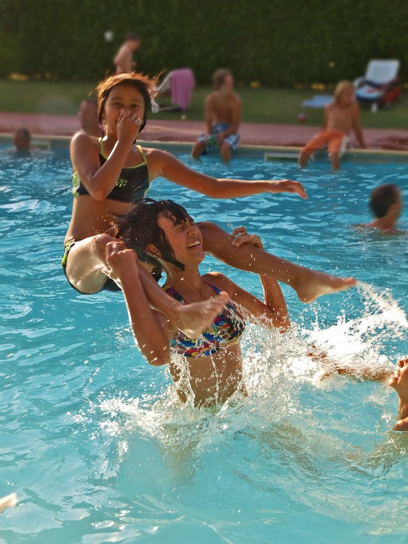 Nens divertits jugant a jocs de piscina