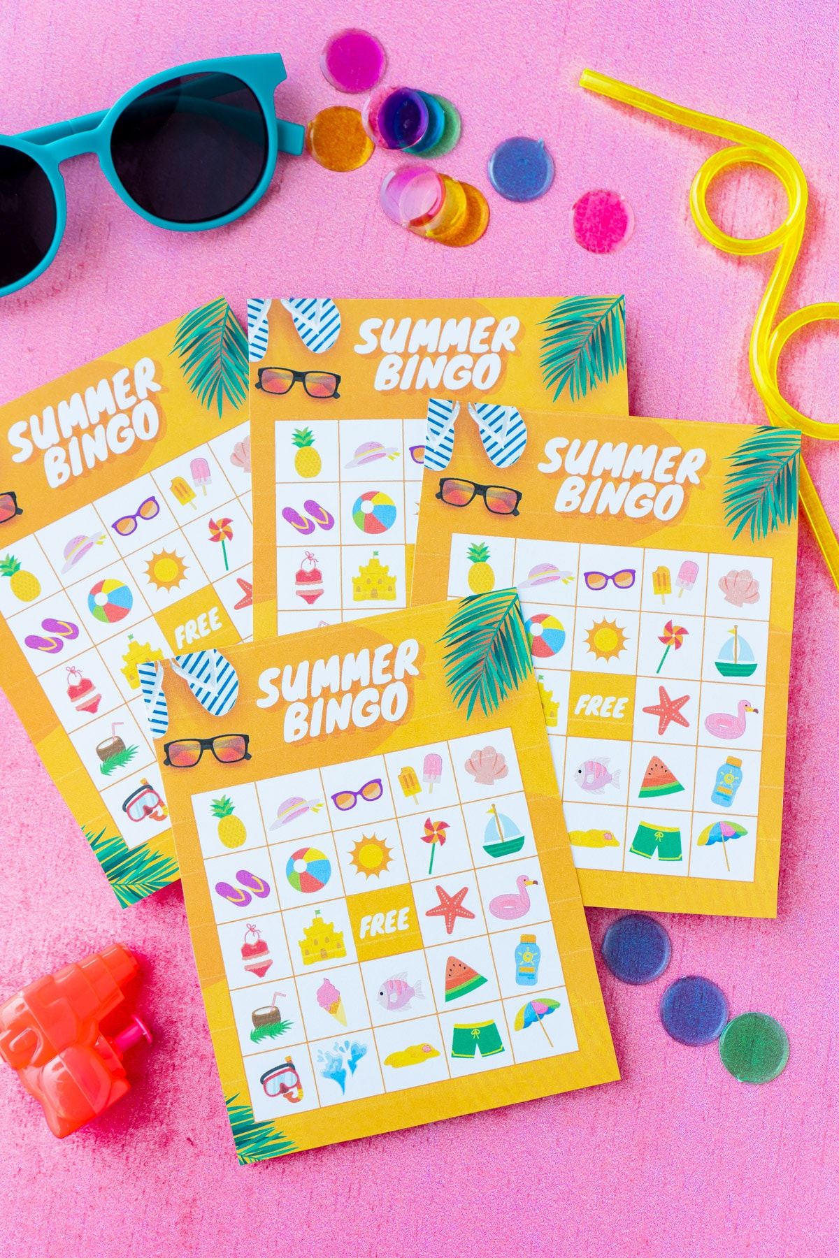 धूप के चश्मे और बिंगो मार्करों के साथ चार नारंगी ग्रीष्मकालीन बिंगो कार्ड