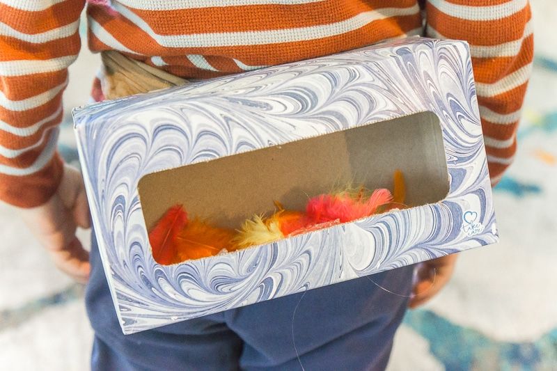 Una caja de pañuelos llena de plumas para los juegos familiares de Acción de Gracias