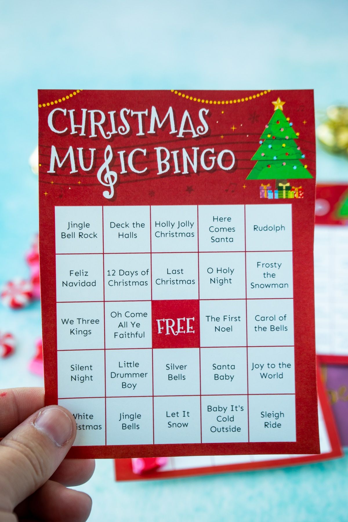 Mano sosteniendo una tarjeta de bingo de música navideña
