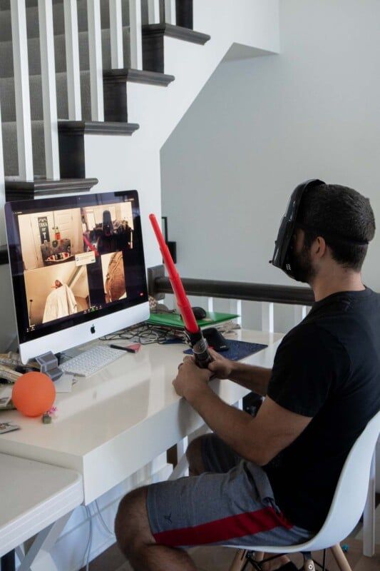 Pria bertopeng Star Wars duduk di depan layar komputer