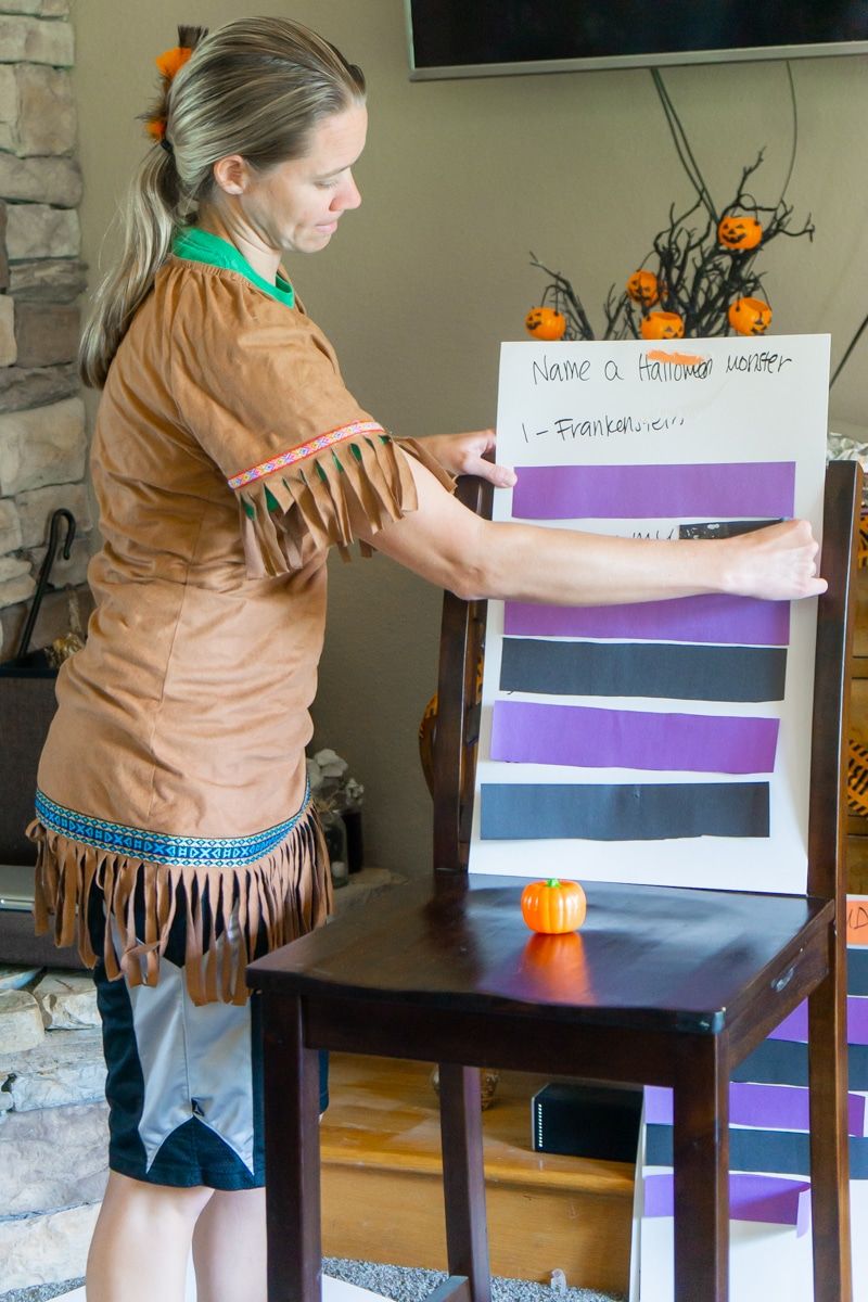 Žena vyberajúca papier zo správnych sporových otázok o rodine Halloween