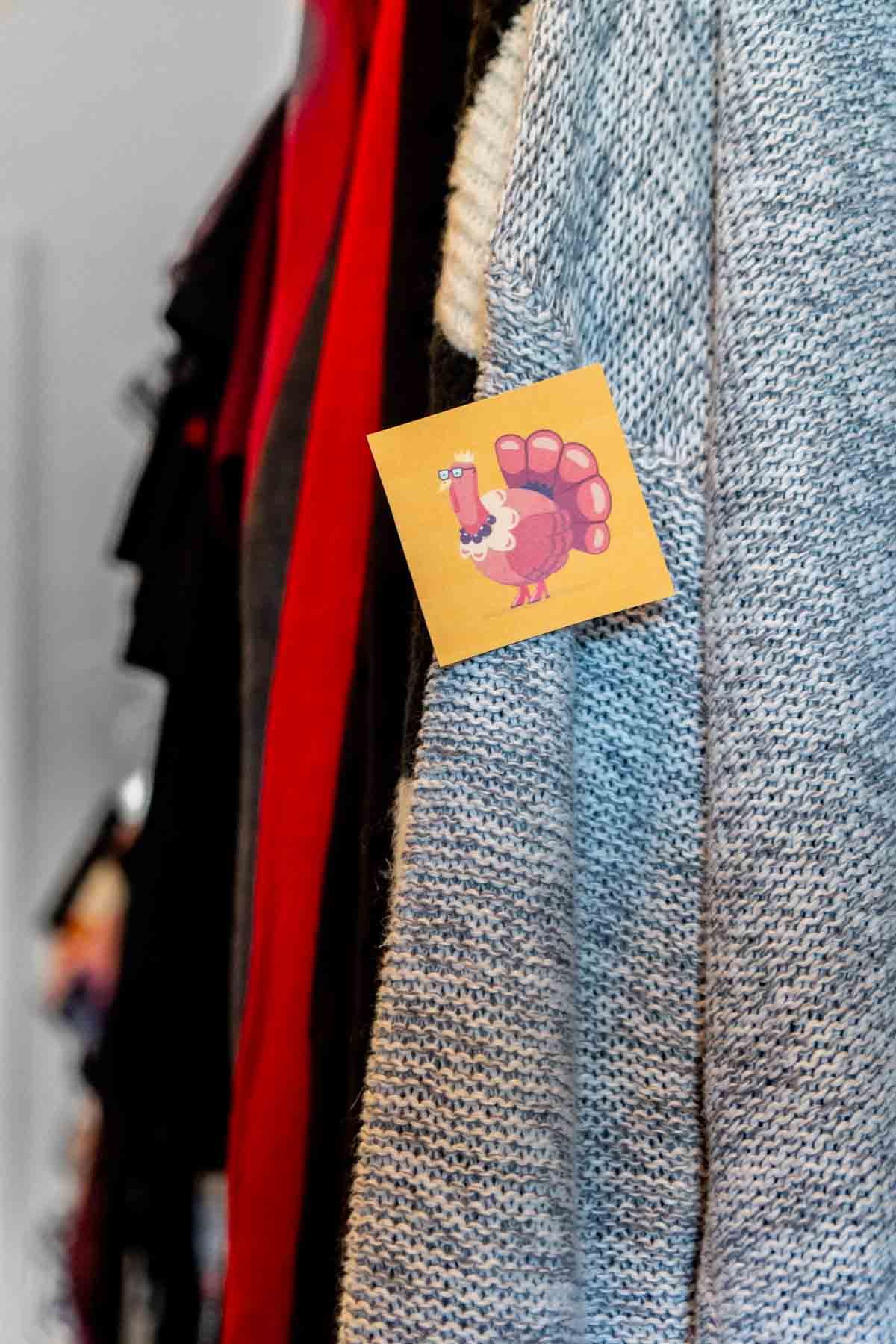 Tarjeta de pavo escondida en un suéter en un armario