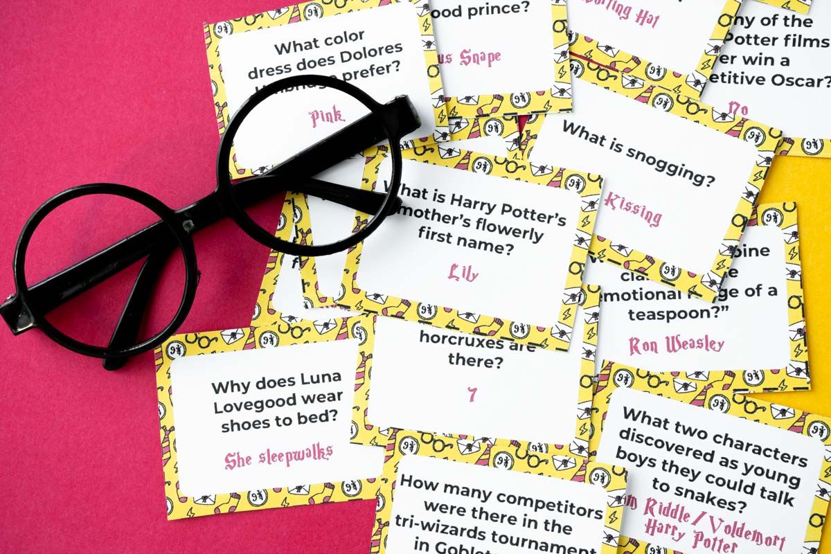 Pila de preguntas de trivia de Harry Potter con un fondo amarillo y un par de vasos de plástico