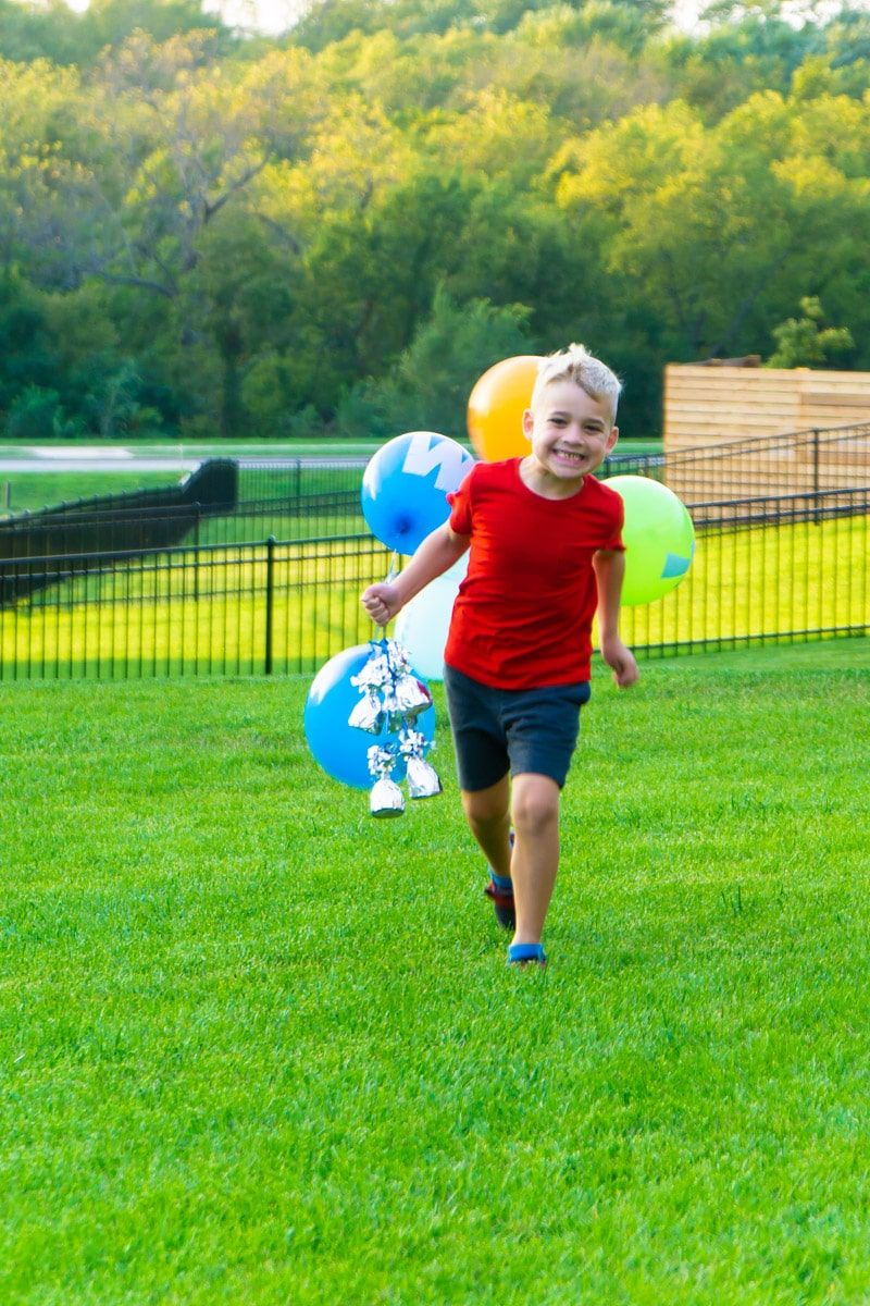 Dítě drží balónky s pravopisnými hrami
