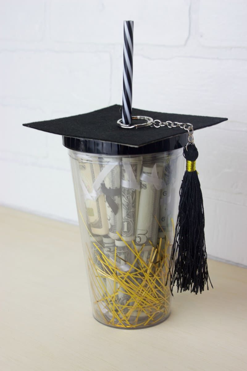 Vaso de plástico con regalos de graduación en el interior
