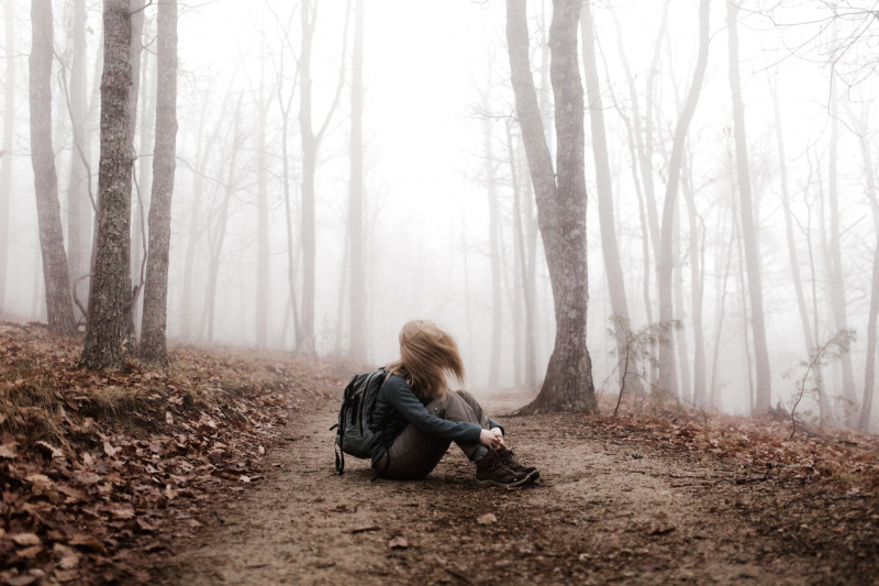   Un caminante sentado en un sendero en el bosque