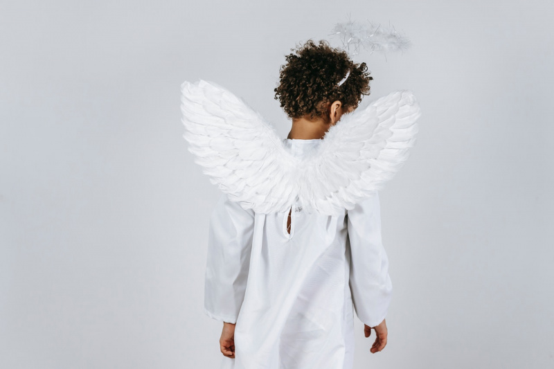   Laps õrnade tiibadega valge ingli kostüümis