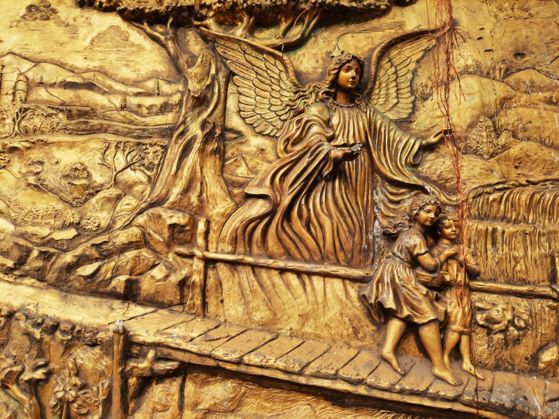   Escultura d'un àngel guiant dos nens