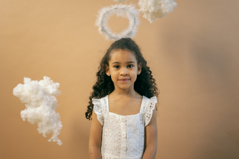  Adorable niña en traje de ángel con nimbus