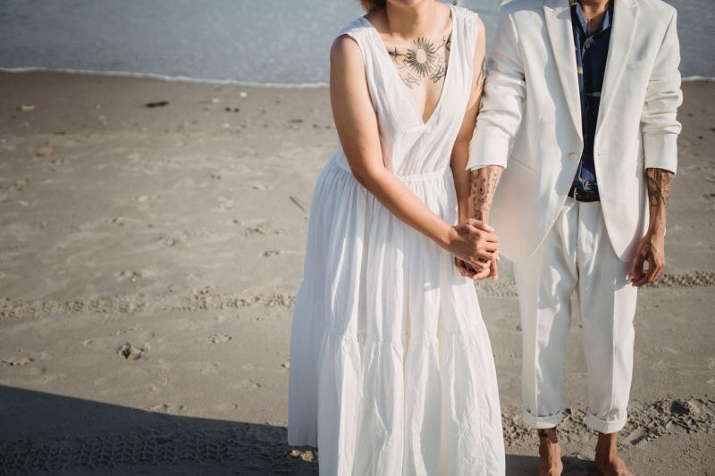   해변에 서 있는 흰색 민소매 드레스를 입은 여자
