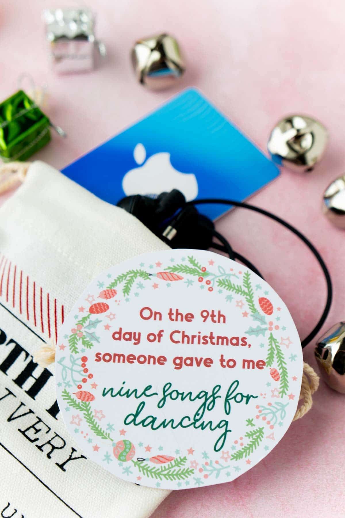 12 días de etiquetas de regalo de Navidad encima de una media con una tarjeta de regalo y campanas