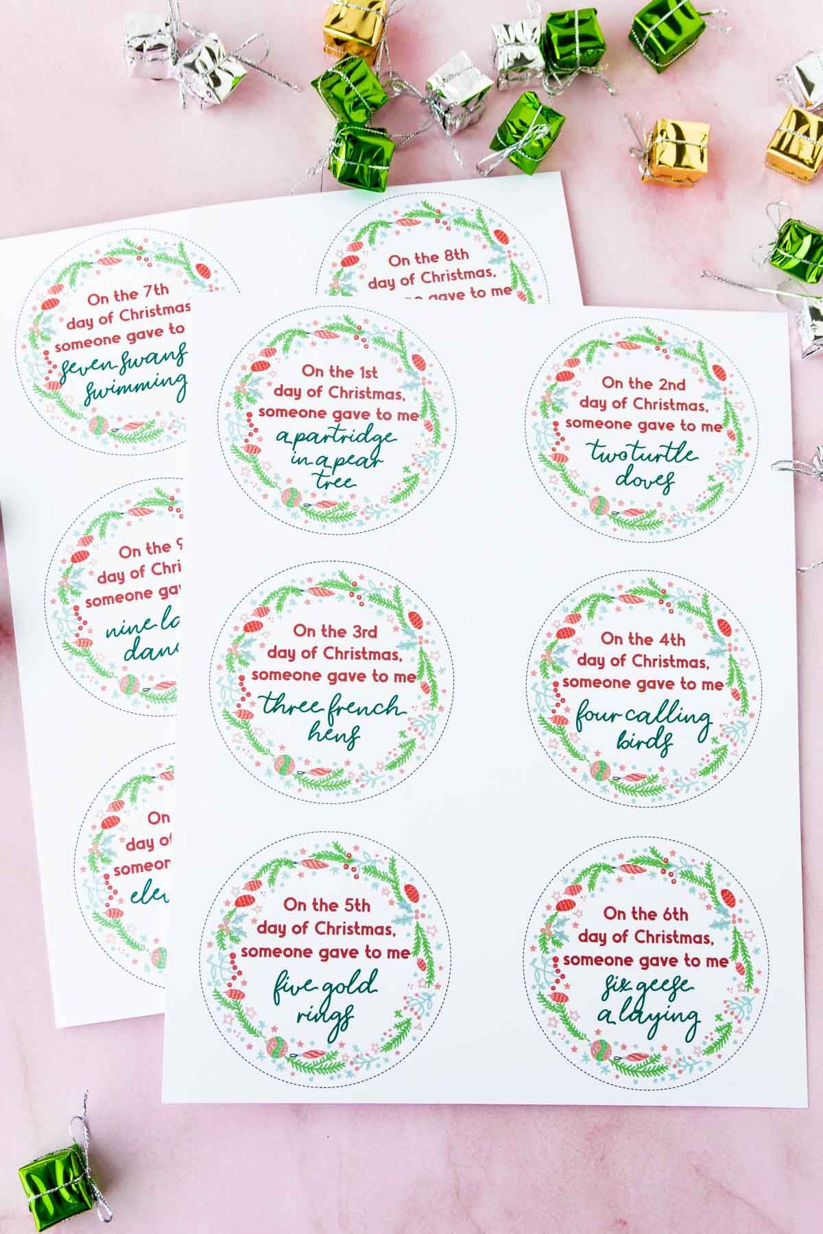 Etiquetas para 12 días de regalos de Navidad sobre fondo rosa