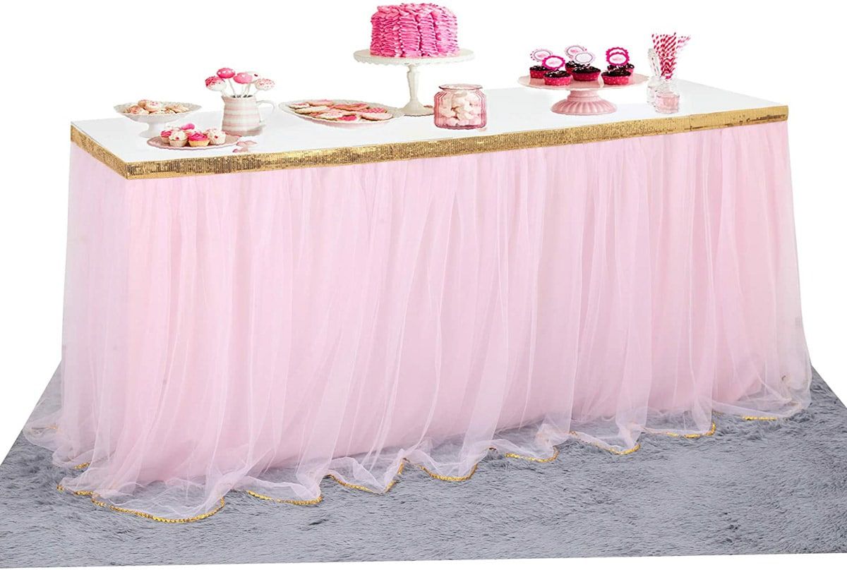 una falda de mesa de tul rosa con elementos rosas en la mesa
