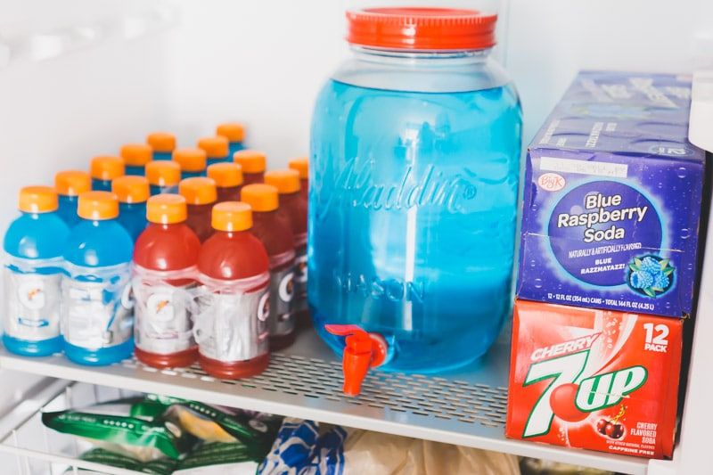 Bebidas rojas, blancas y azules cargadas en estantes de metal en el Gladiator All Refrigerator