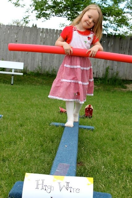 Ένα κορίτσι που περπατά ένα σύρμα μίσθωσης σε ένα πάρτι τσίρκου