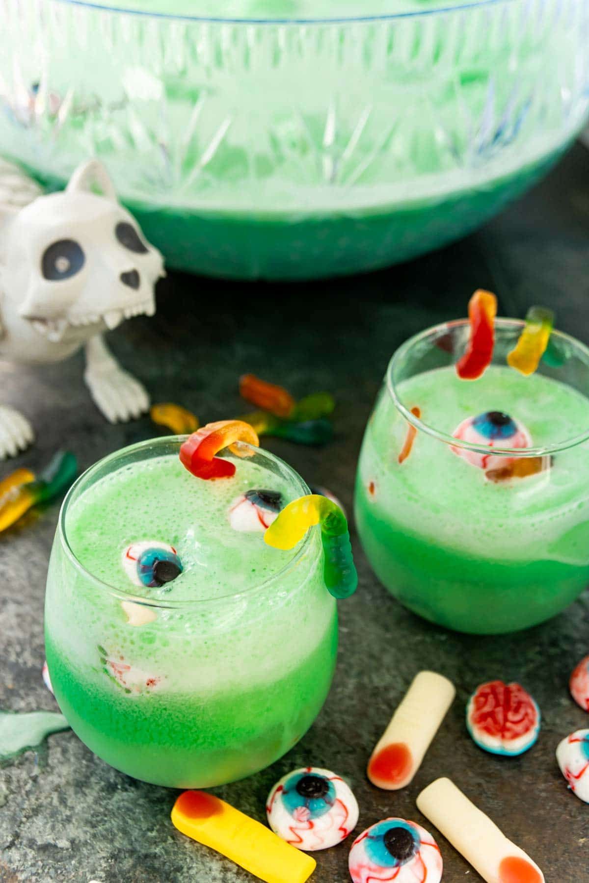 Dos vasos de ponche verde de Halloween con un gato zombie