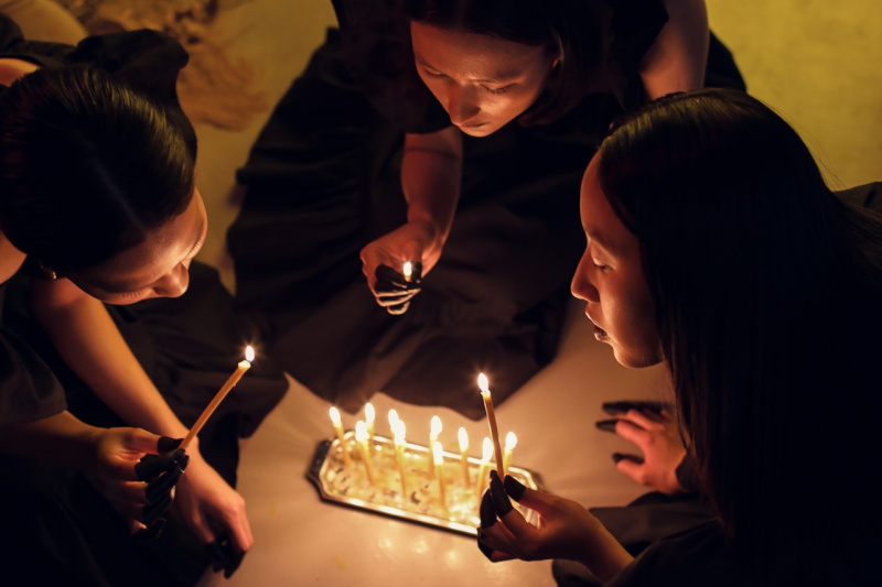   Grupa kobiet trzymających zapalone świece