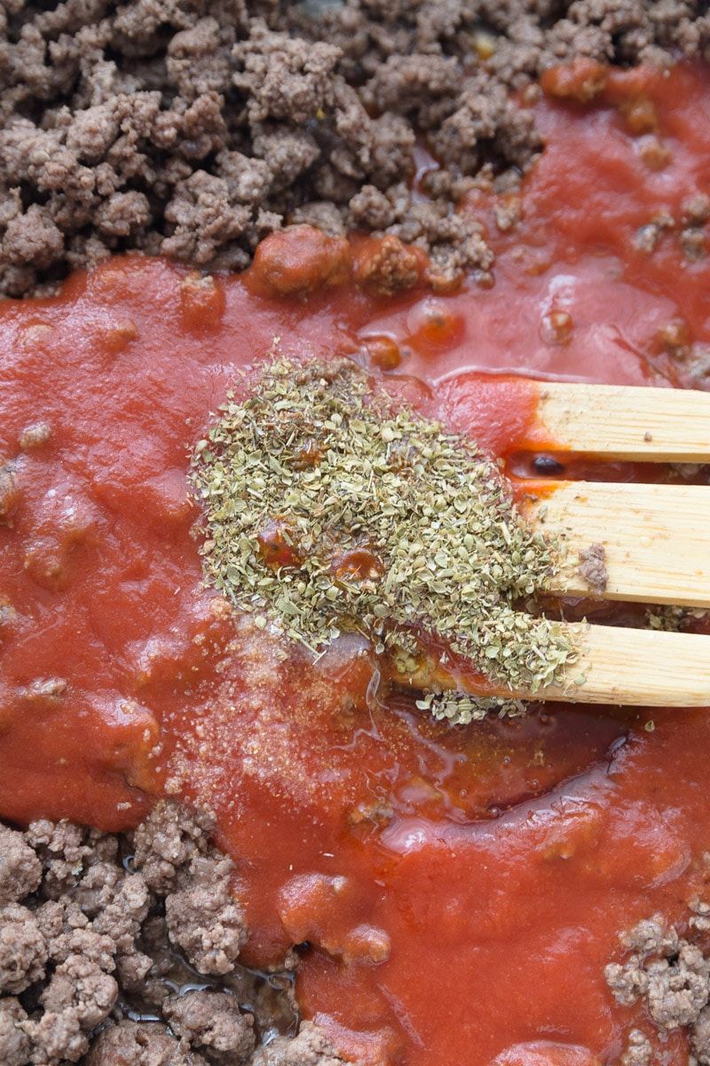 Una cucharada llena de especias en la mejor receta de salsa para espaguetis