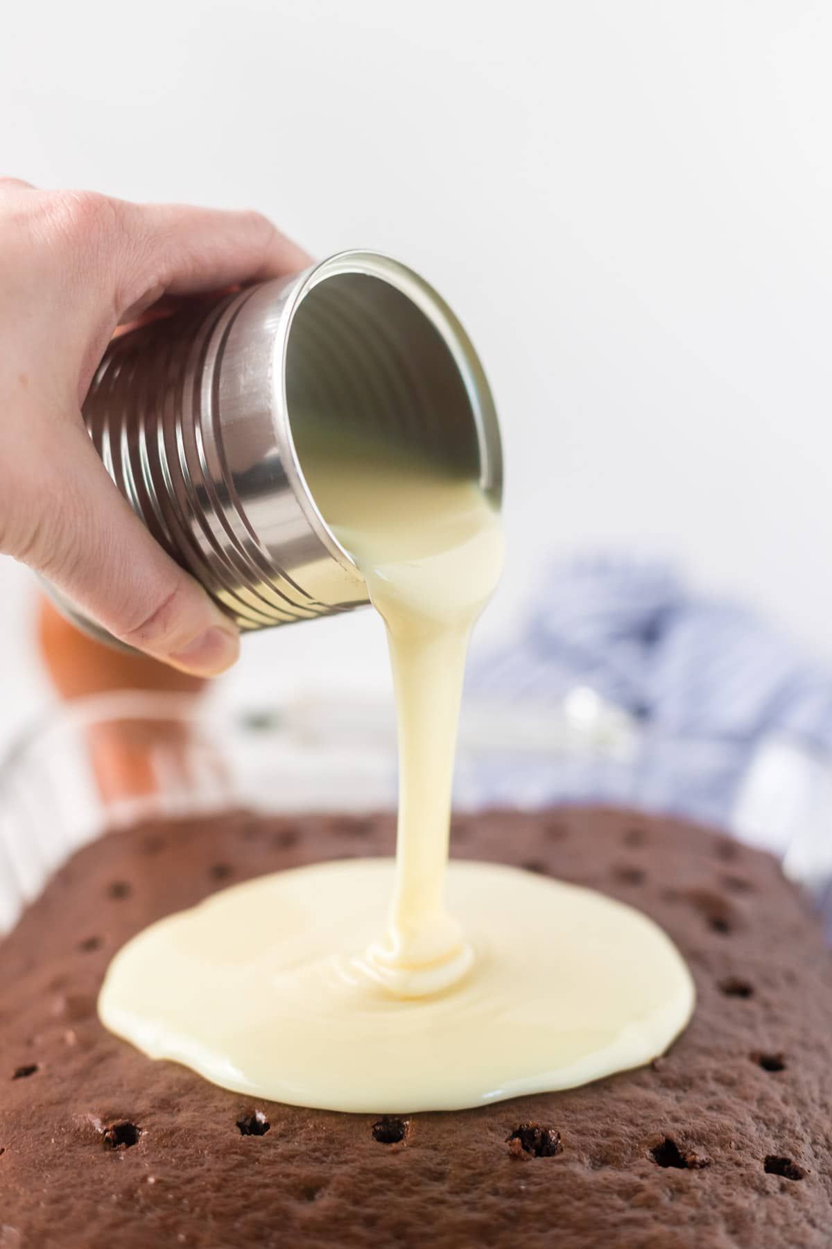 Verter la leche condensada sobre el pastel de chocolate