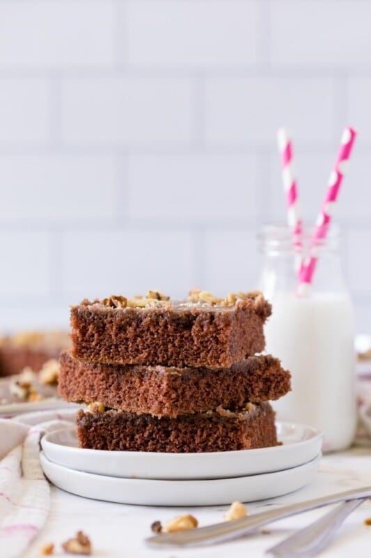 Tres rebanadas de pastel de brownie de chocolate apiladas una encima de la otra con leche en el fondo