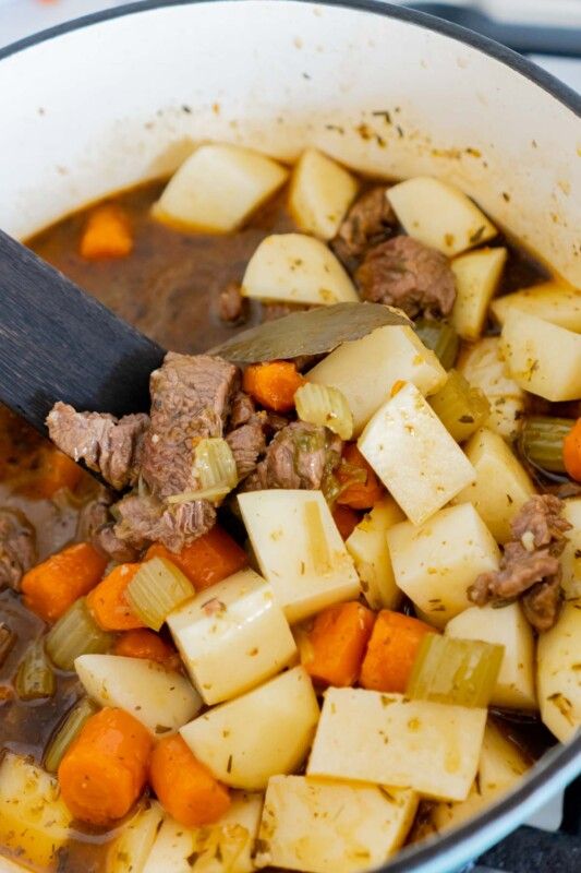 Ajouter des pommes de terre dans une casserole de ragoût de bœuf