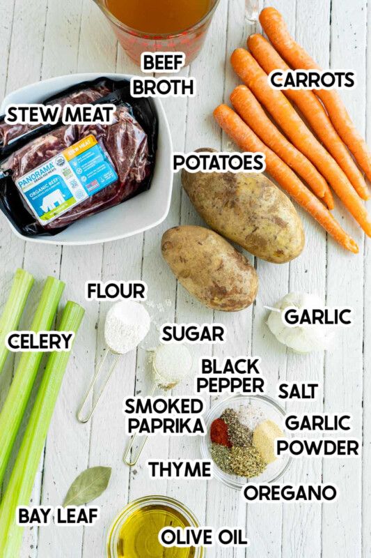 Carne, zanahorias, patatas y especias sobre un fondo de madera blanca