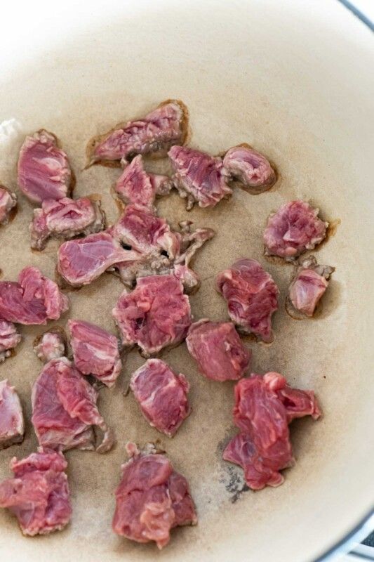 Morceaux de viande de ragoût de brunissement dans un pot en céramique