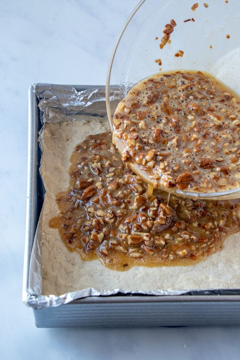 Pekanriekstu pīrāgu batoniņus lej uz smilšu maizes garozas