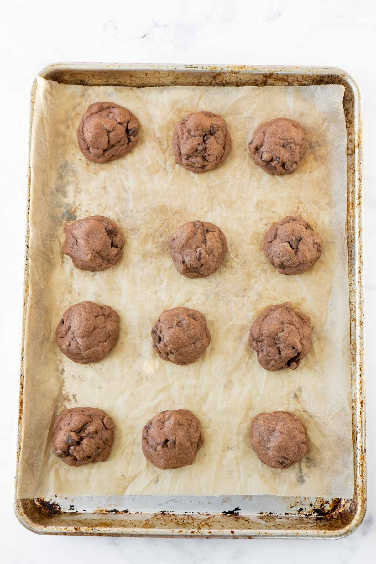čokoládové pudinkové sušenky v řadách na plechu na pečení