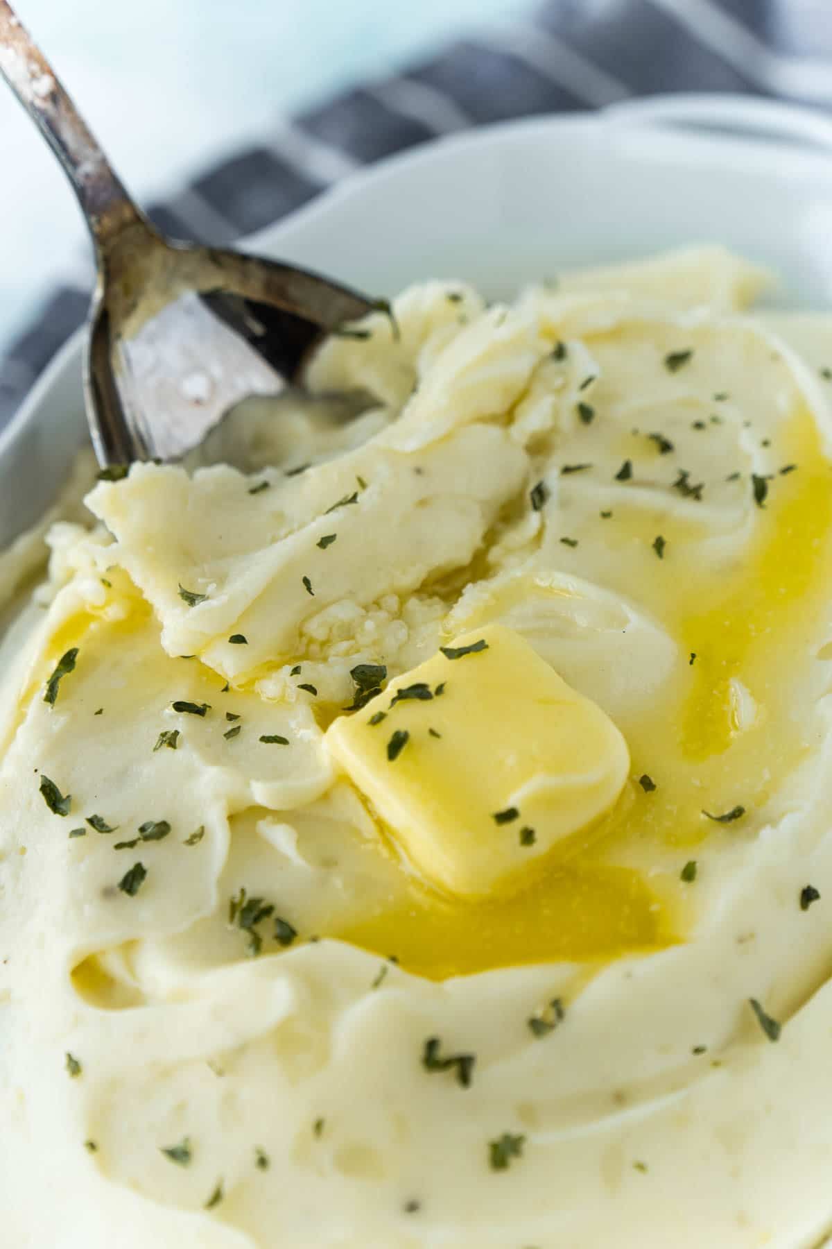 위에 버터와 으깬 감자 그릇에 금속 숟가락