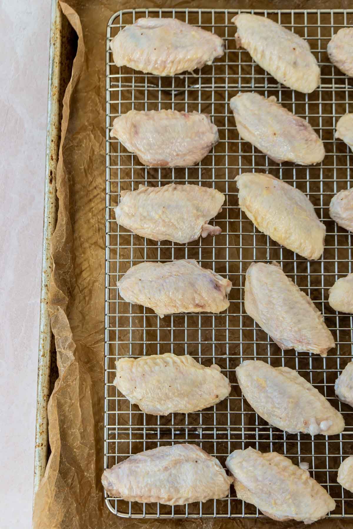 Φτερούγες κοτόπουλου σε ένα ράφι καλωδίων σε ένα τηγάνι