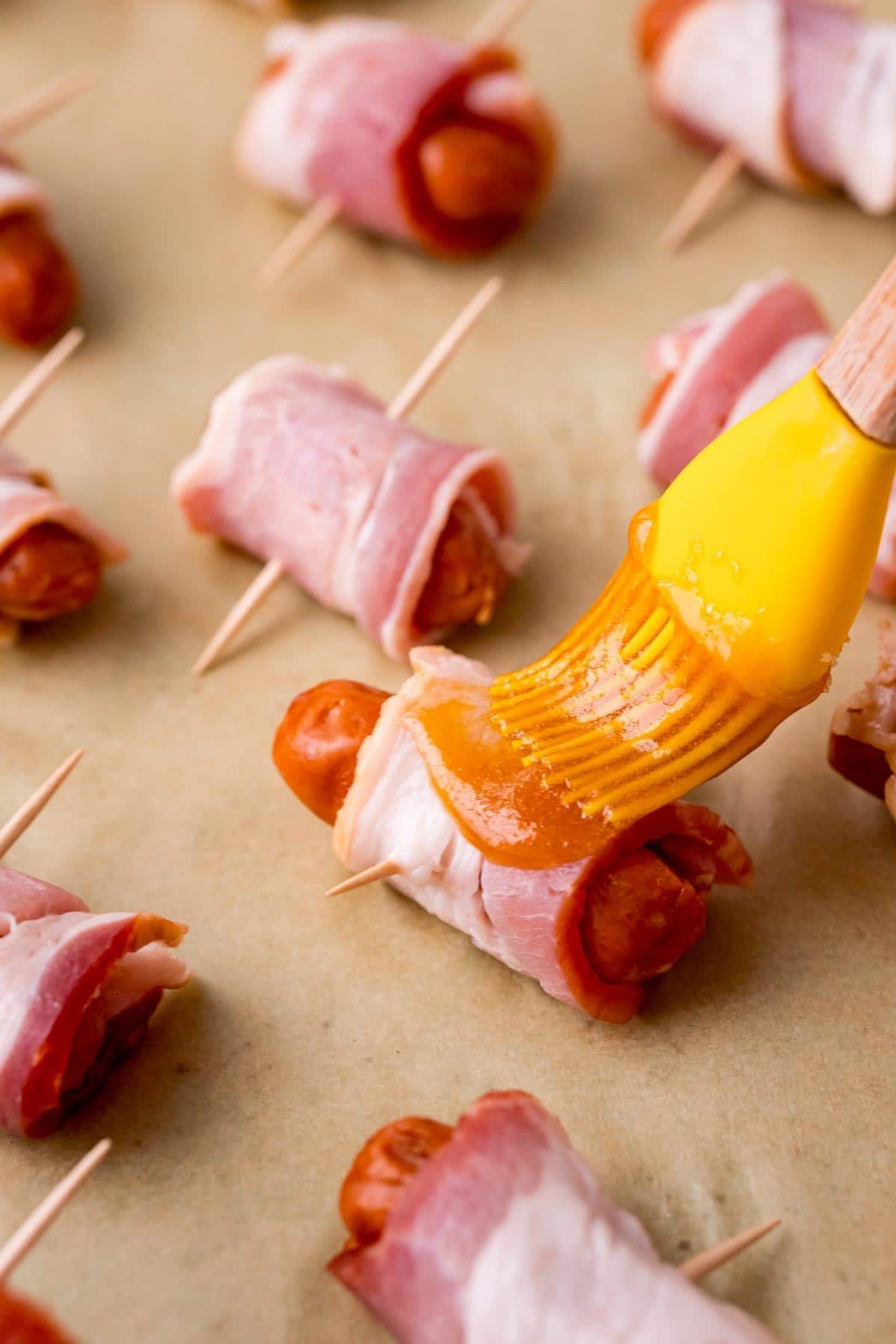 Kartáčování glazury z hnědého cukru na slaninách zabalených ve slanině